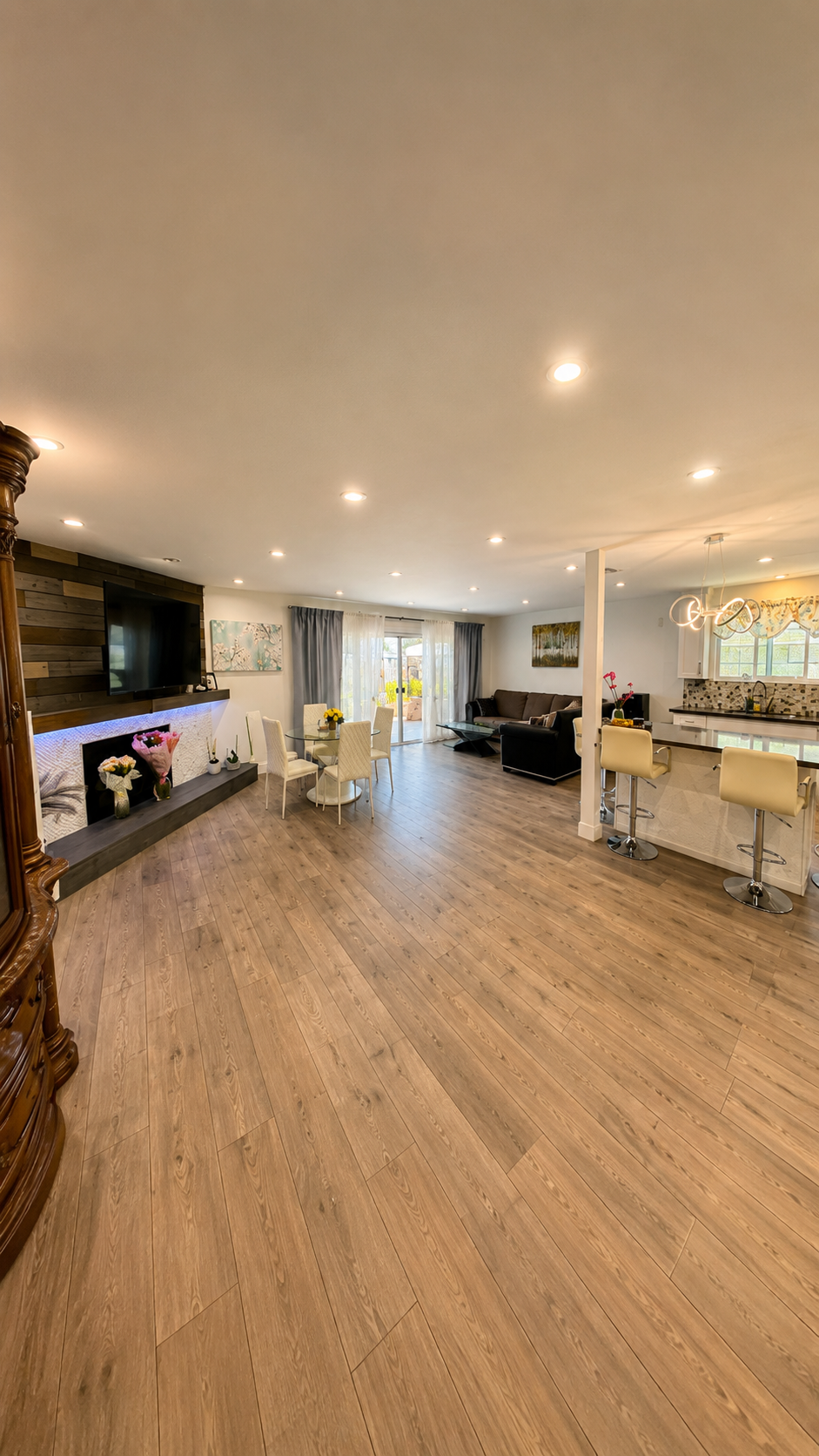 Open living room with stone fireplace, comfortable seating and warm light at Love & Care Boarding Home